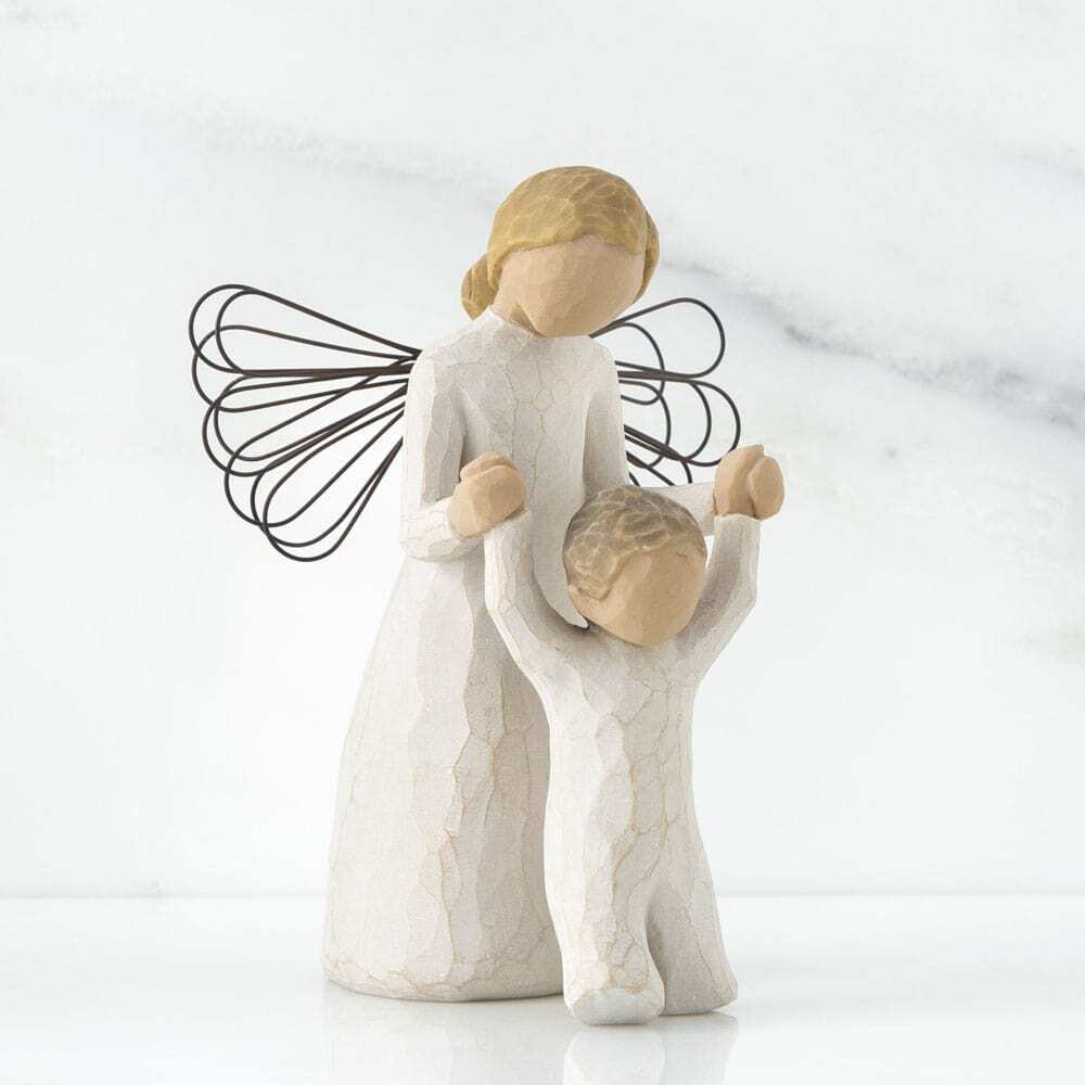Guardian Angel by Willow Tree. Female angel in cream dress and wire wings, holding both hands of toddler in cream onesie walking in front of angel