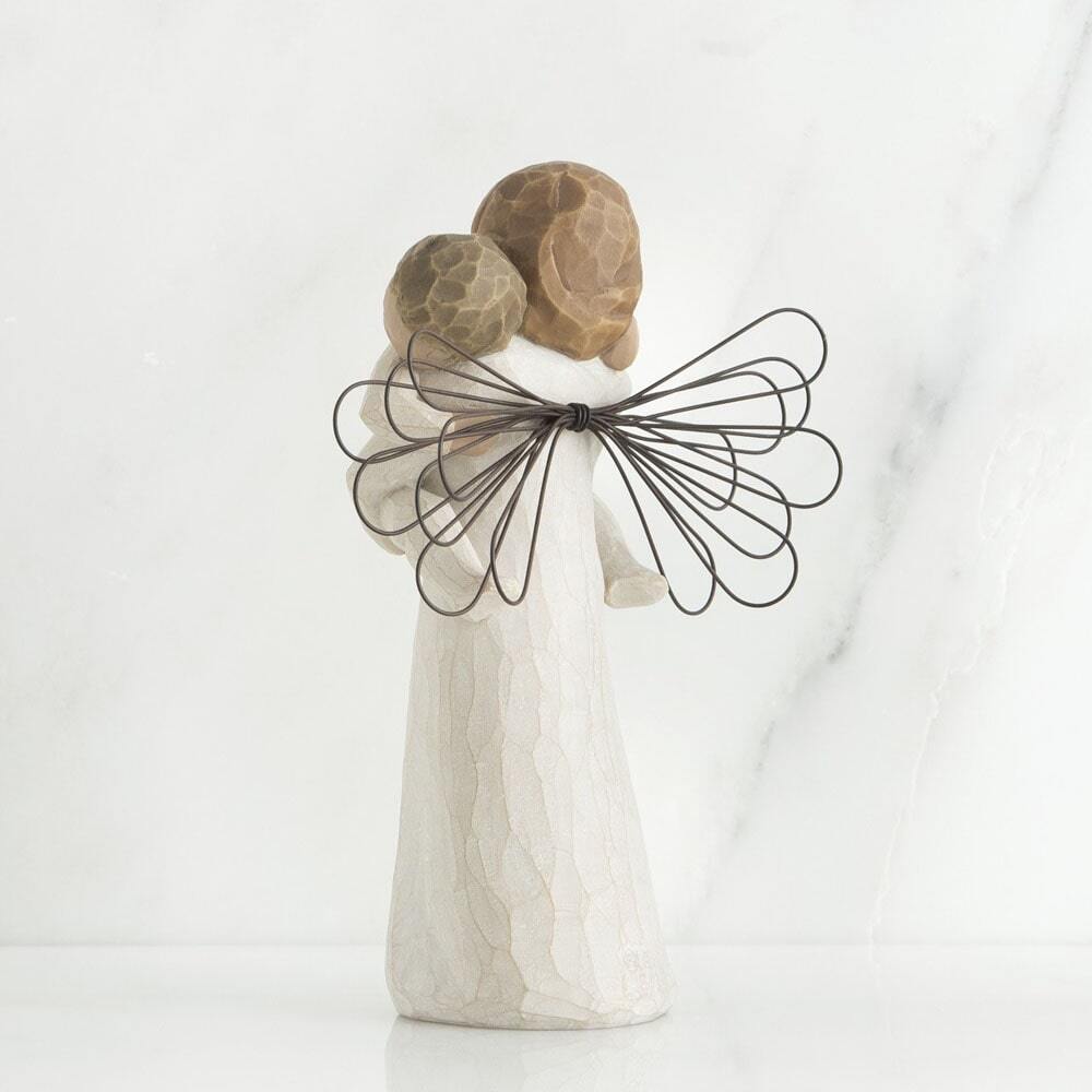 Angel's Embrace by Willow Tree. Back View - Standing female angel in cream dress with wire wings, holding baby in cream onesie, in arms