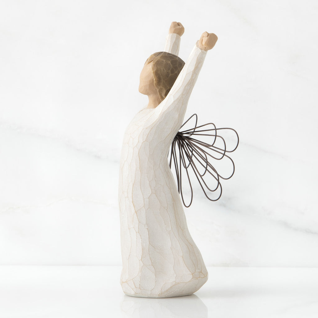 Standing angel in cream dress with wire wings, with both arms upraised