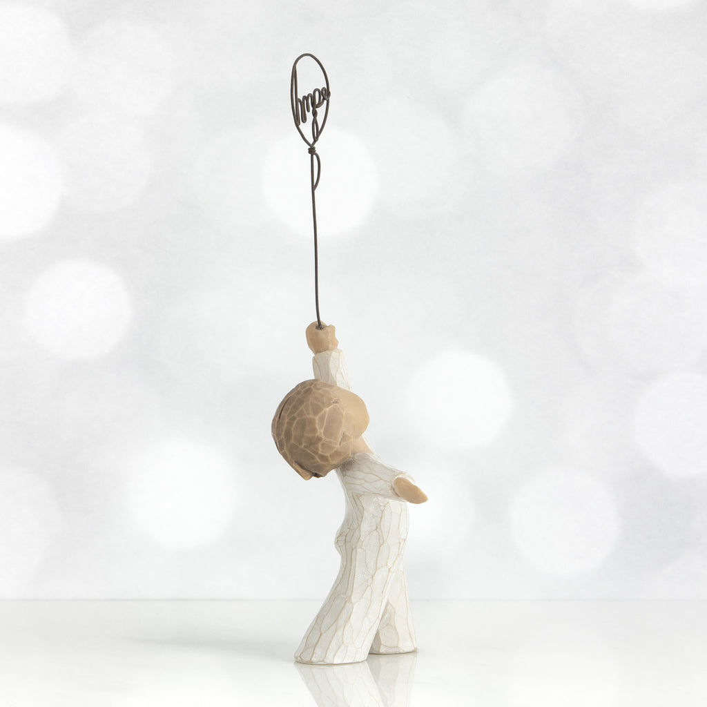 Hope by Willow Tree. Standing figure in cream onesie, holding wire balloon with the word 'hope' written in wire inside it