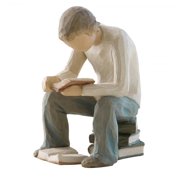 Figure of young man in cream shirt and blue jeans, seated on stack of books, reading book