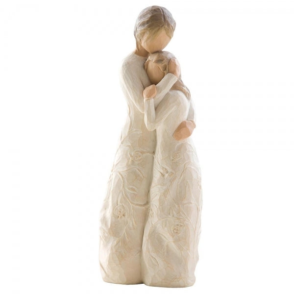 Figure of standing older woman embracing younger girl, both in cream dresses carved with intertwined vines and leaves