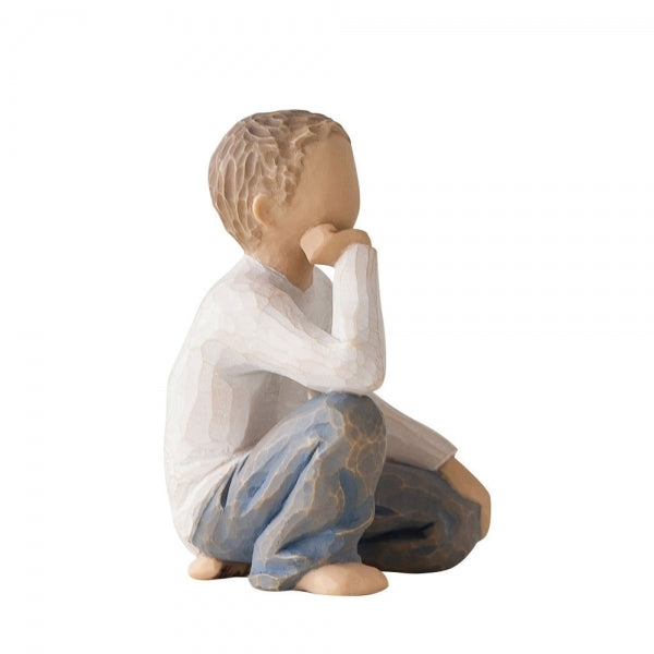 Figure of half-kneeling boy in cream shirt and blue jeans, with hand under chin