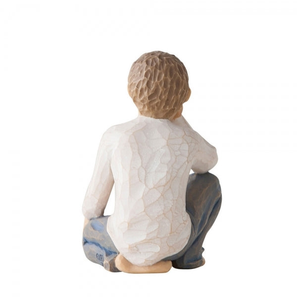 Back View: Figure of half-kneeling boy in cream shirt and blue jeans, with hand under chin