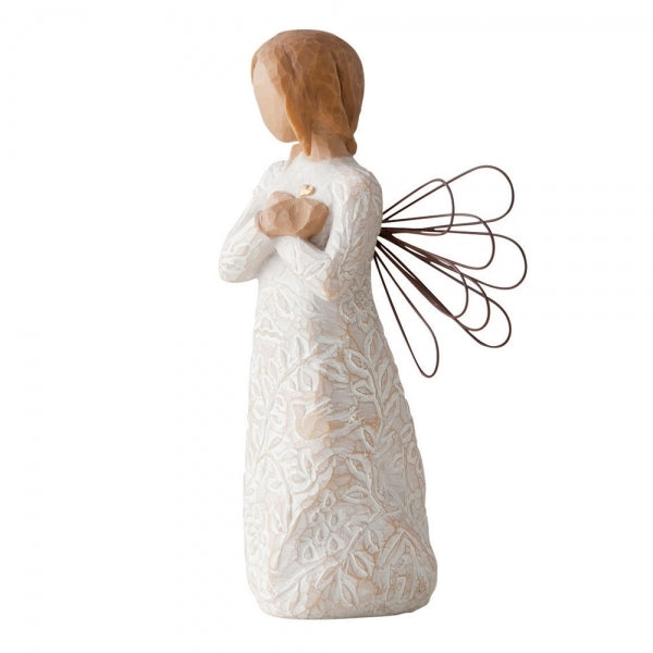 Standing angel in cream dress with wire wings, with crossed hands under small gold-leaf heart. Dress carved with symbols of nature