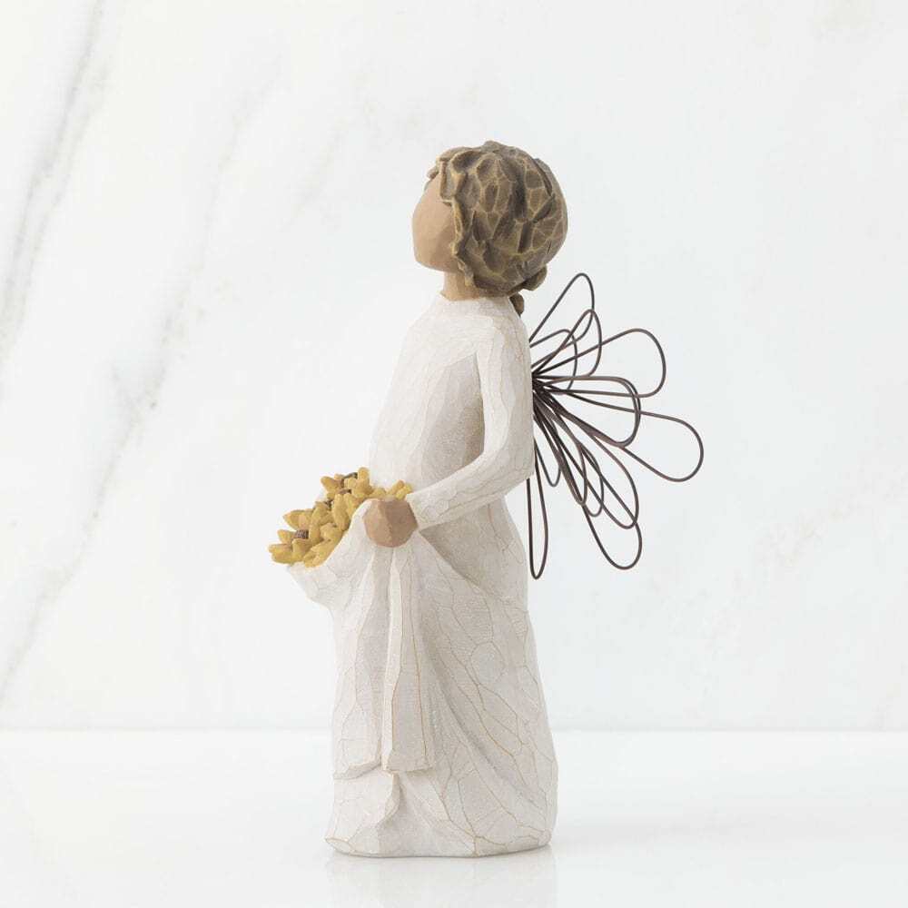 Standing female angel with darker skin tone and hair colour, in cream dress and wire wings, holding up skirt filled with black-eyed susan flowers