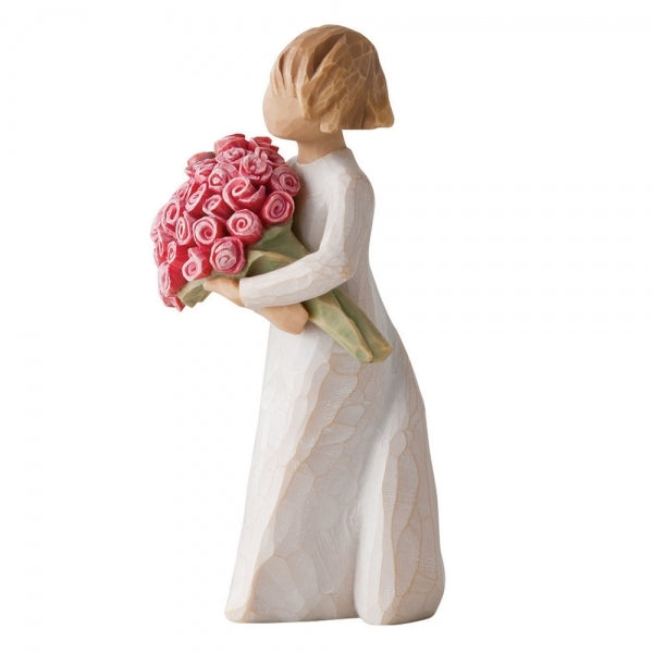 Standing female figure in cream dress holding large bouquet of pink roses