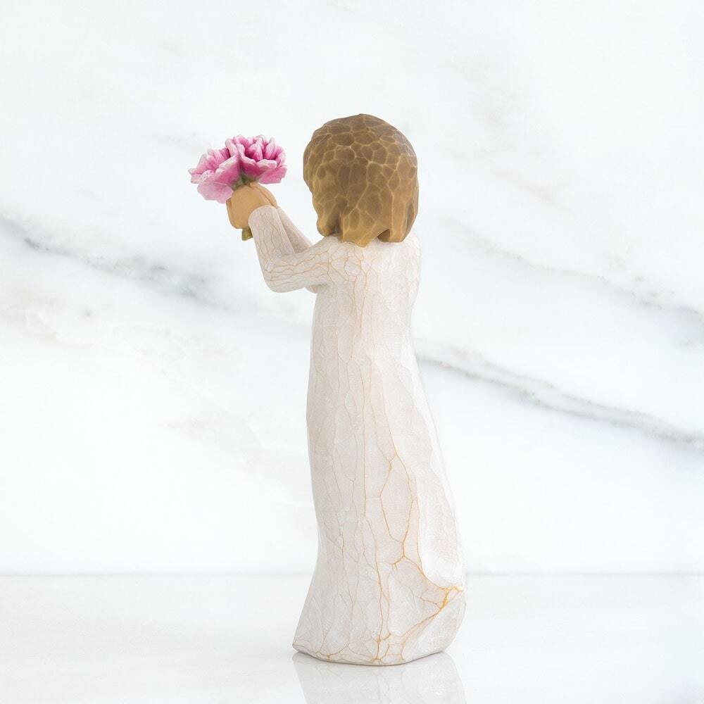 Standing figure in cream dress, holding out small bouquet of pink peonies
