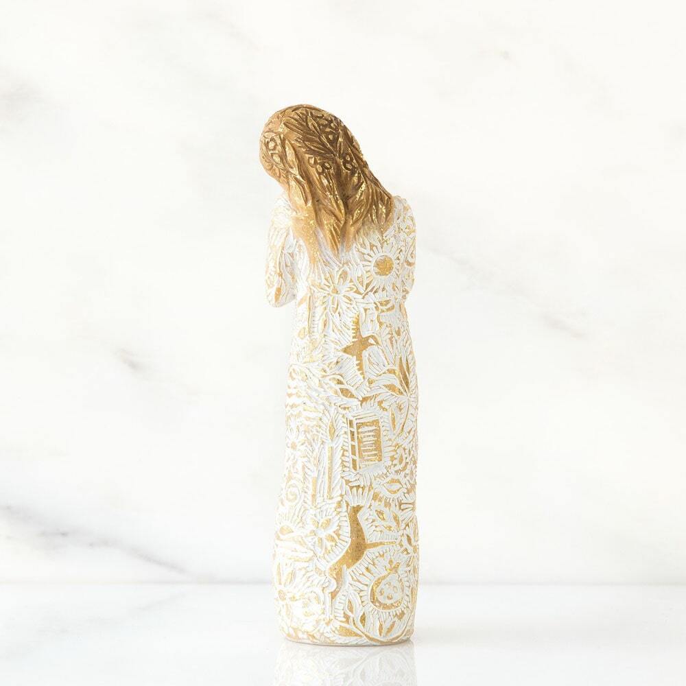 Standing figure, hands crossed at chest. Dress, hair, hands and head extensively carved with symbols of nature and memories. Gold-leaf rubbing on entire figure