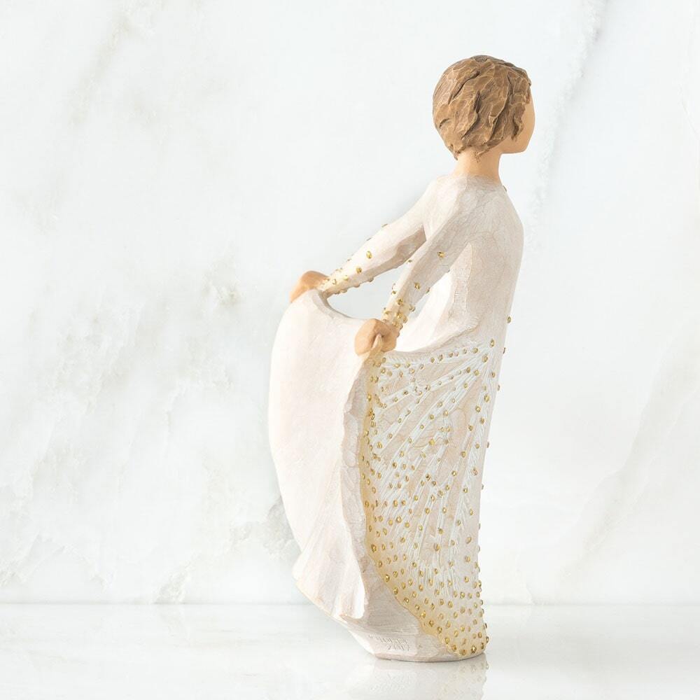 Standing figure in cream dress, holding the sides of her skirt out with both hands. Skirt has carved markings of a monarch butterfly, dotted with gold leaf
