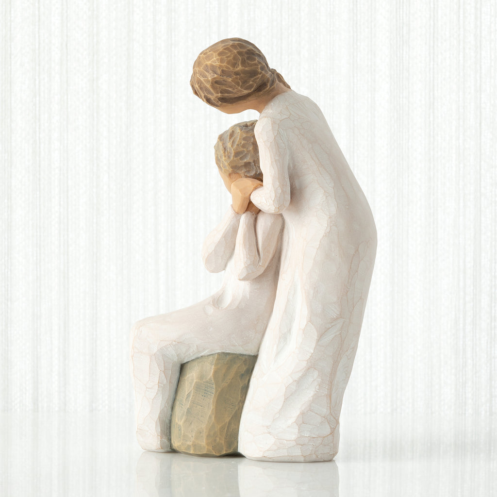 Loving My Mother by Willow Tree. Seated older female figure in cream dress, with younger female in cream dress, standing at her shoulder, hands clasped in embrace